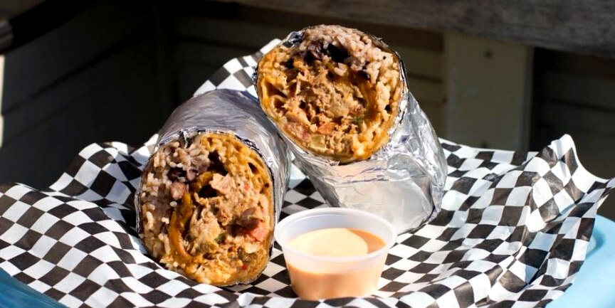 A Cuban burrito filled with pulled pork, black beans, and rice